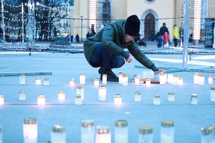 People lighting candles in memory of victims of deportations in Tallinn's Freedom Square. Source: Ken Mürk/ERR
